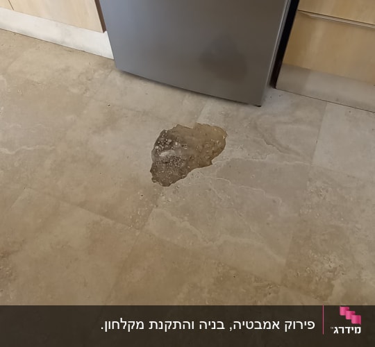 רצפה עם כתם רטיבות ליד מקרר נירוסטה